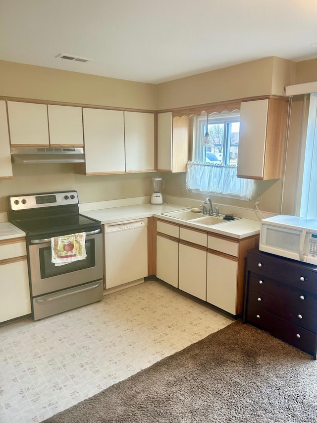 kitchen with white appliances, visible vents, light floors, light countertops, and under cabinet range hood