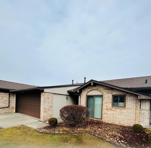 view of front of house with brick siding, driveway, and an attached garage