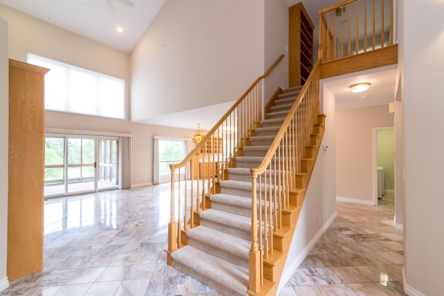 stairs featuring baseboards, high vaulted ceiling, and recessed lighting