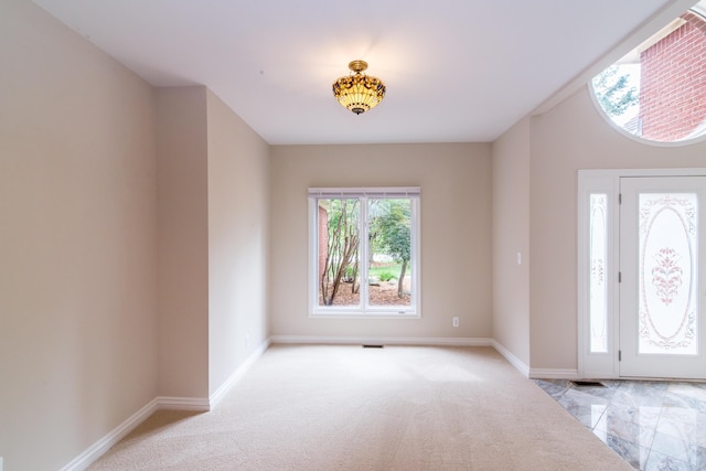 foyer with light carpet and baseboards