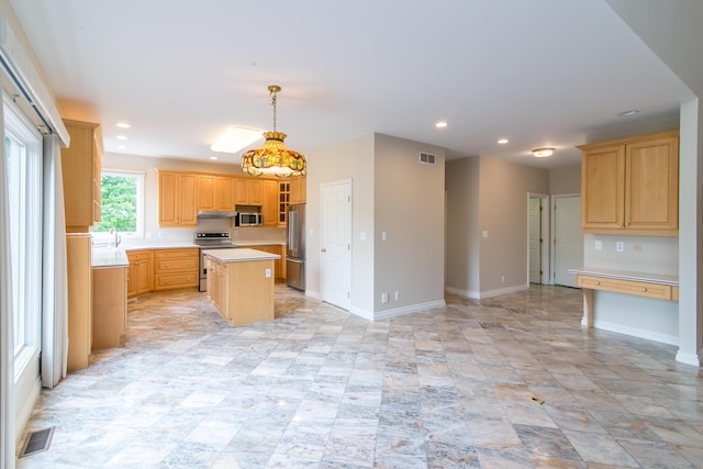 kitchen with visible vents, a kitchen island, appliances with stainless steel finishes, light countertops, and under cabinet range hood