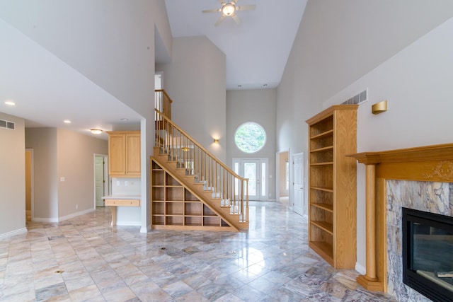 unfurnished living room featuring baseboards, stairs, visible vents, and a premium fireplace