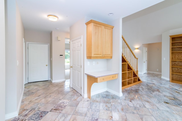 kitchen featuring light brown cabinets, baseboards, and light countertops