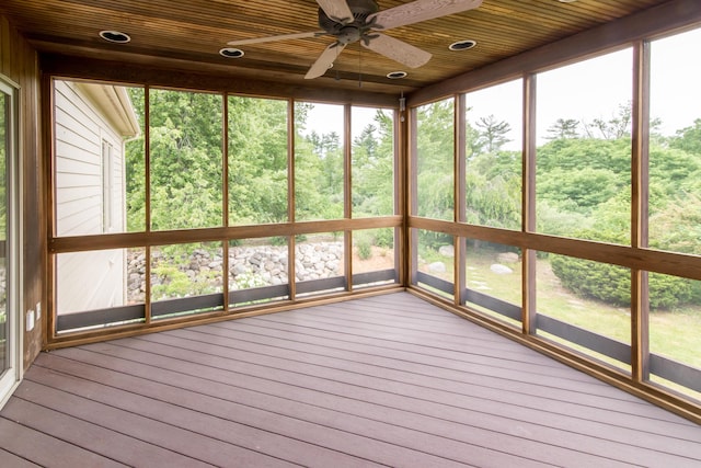 unfurnished sunroom featuring wood ceiling and a ceiling fan