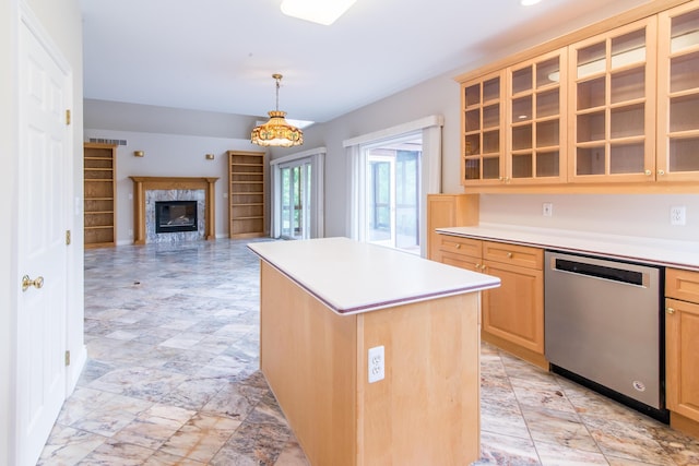 kitchen featuring a kitchen island, light countertops, dishwasher, light brown cabinetry, and glass insert cabinets