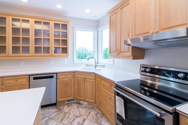 kitchen featuring stainless steel appliances, recessed lighting, light brown cabinetry, a sink, and under cabinet range hood