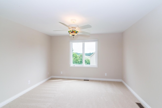 unfurnished room featuring baseboards, ceiling fan, visible vents, and light colored carpet