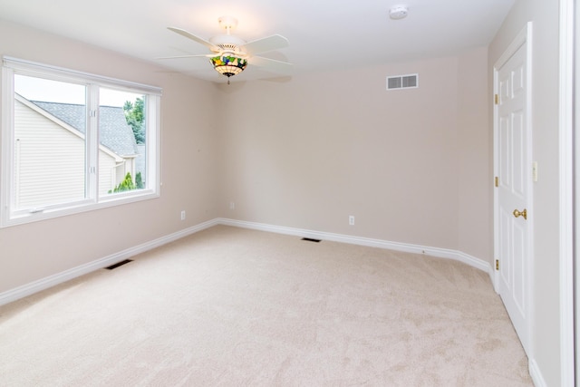 spare room featuring visible vents, light carpet, and baseboards