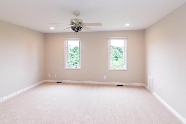 unfurnished room featuring light colored carpet, plenty of natural light, and baseboards