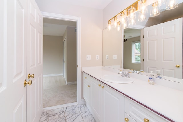 bathroom featuring marble finish floor, vanity, and baseboards