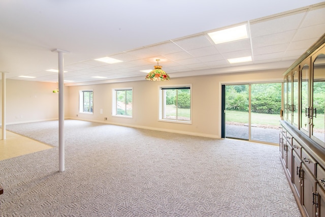 interior space with carpet, a paneled ceiling, and baseboards