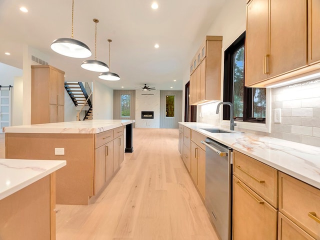 kitchen with a barn door, a kitchen island, a sink, visible vents, and stainless steel dishwasher