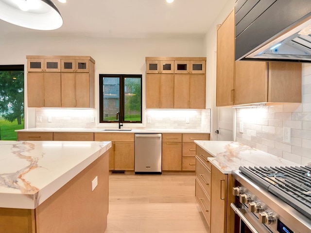 kitchen featuring stainless steel appliances, light brown cabinets, a sink, and extractor fan