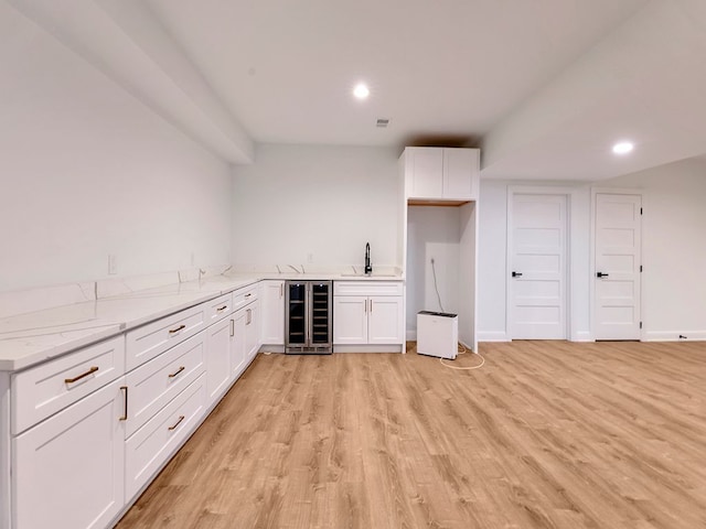 bar featuring wine cooler, wet bar, light wood-style floors, a sink, and recessed lighting