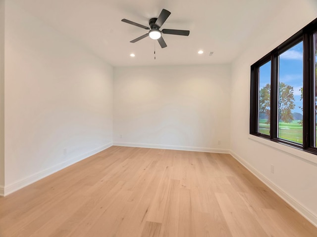 spare room with light wood finished floors, recessed lighting, a ceiling fan, and baseboards