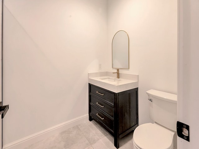 bathroom featuring tile patterned floors, vanity, toilet, and baseboards