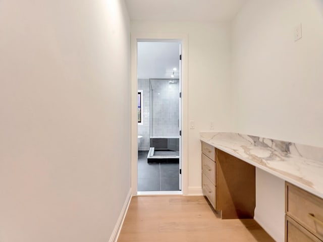 bathroom featuring wood finished floors, vanity, and baseboards