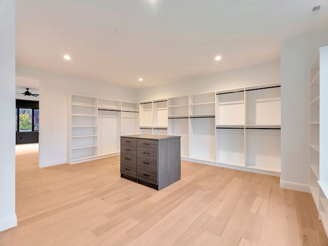 walk in closet with a ceiling fan and light wood-style floors