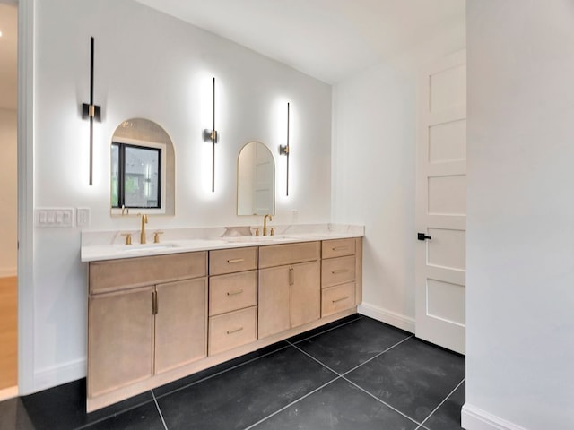 full bathroom featuring double vanity, a sink, and baseboards