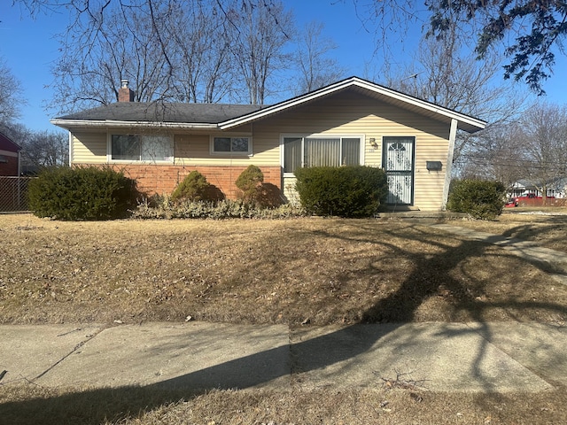 view of front of property featuring brick siding and a chimney