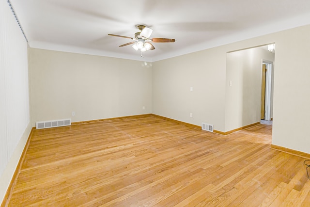 spare room featuring baseboards, light wood finished floors, visible vents, and a ceiling fan