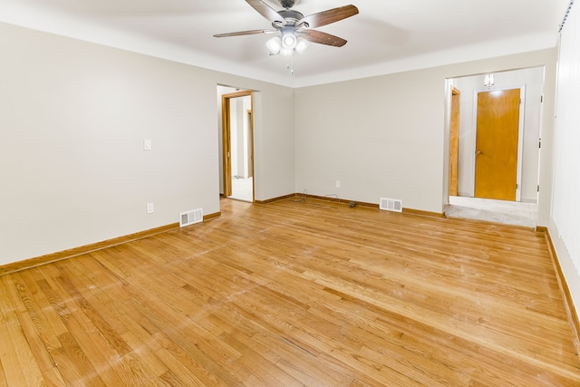 unfurnished room featuring light wood-style flooring, visible vents, and baseboards