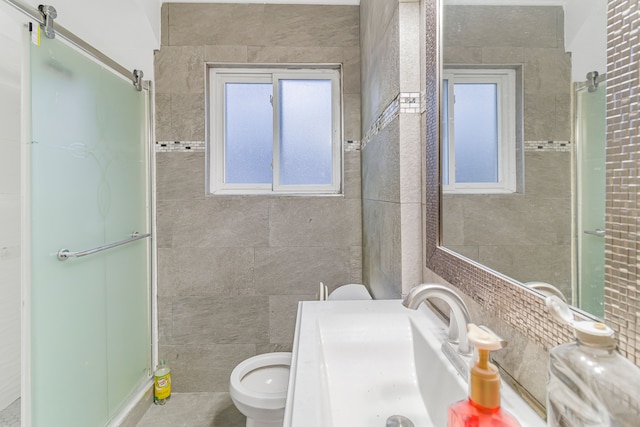 full bath featuring toilet, a stall shower, vanity, and tile walls