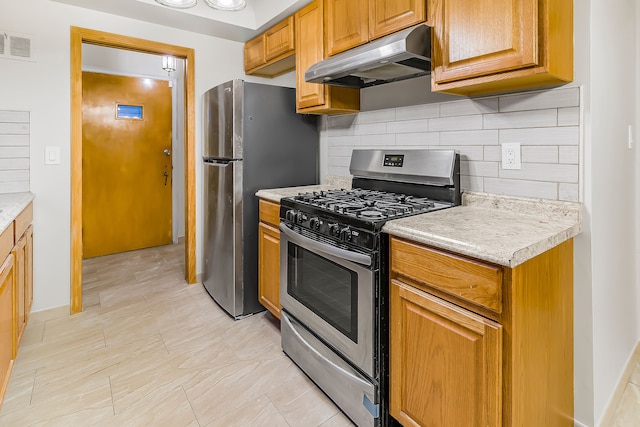 kitchen with appliances with stainless steel finishes, visible vents, light countertops, and under cabinet range hood