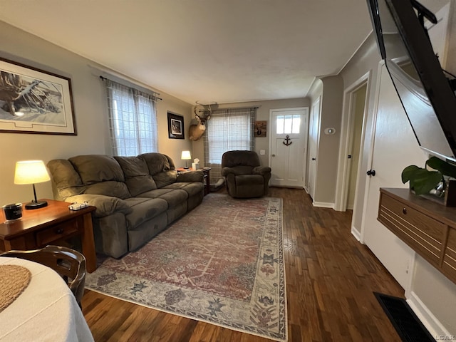 living area featuring baseboards, visible vents, and dark wood-type flooring