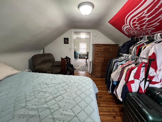 bedroom with lofted ceiling and dark wood finished floors