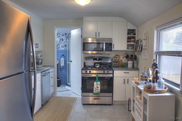 kitchen with stainless steel appliances, plenty of natural light, light tile patterned flooring, and white cabinetry