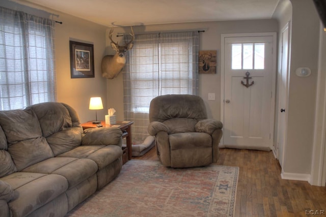 living area featuring baseboards and wood finished floors