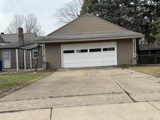 exterior space featuring an attached garage, a chimney, and concrete driveway