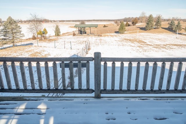 yard covered in snow featuring a rural view