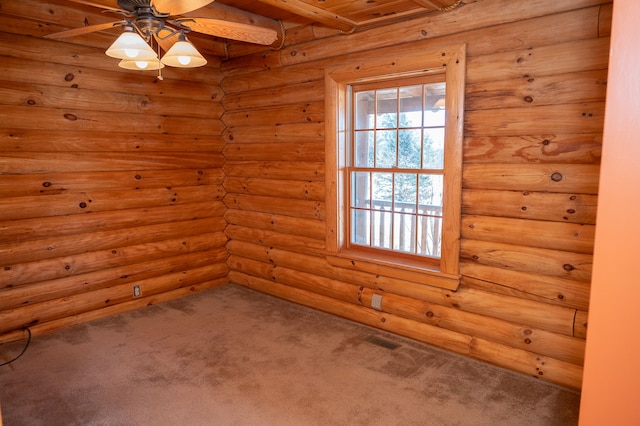 carpeted spare room with visible vents and a ceiling fan