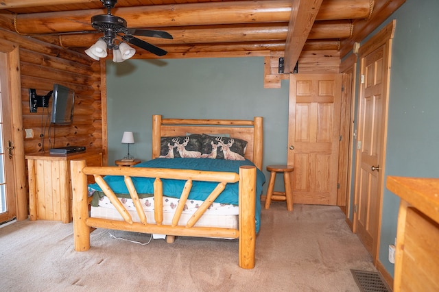 bedroom with carpet floors, beam ceiling, rustic walls, and visible vents