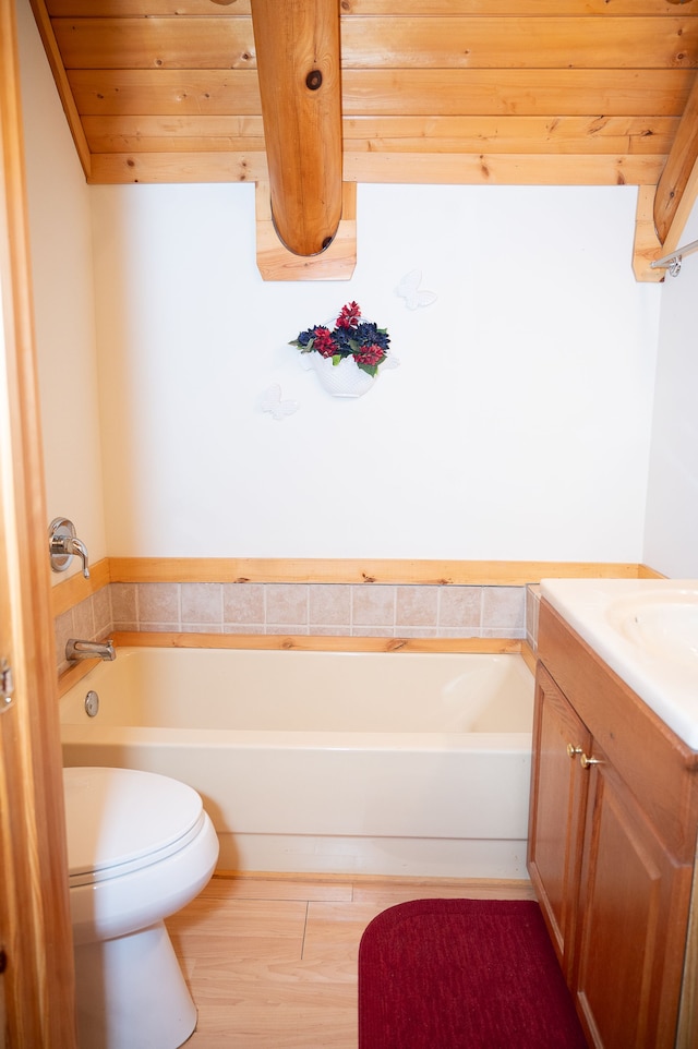 bathroom featuring a tub to relax in, wooden ceiling, vanity, and toilet