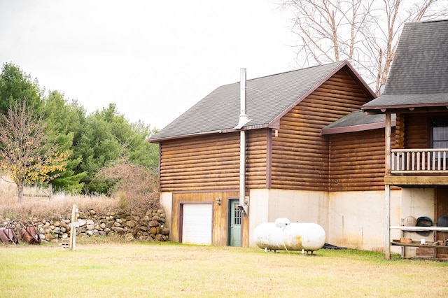 view of side of property with log exterior, a shingled roof, a lawn, and driveway