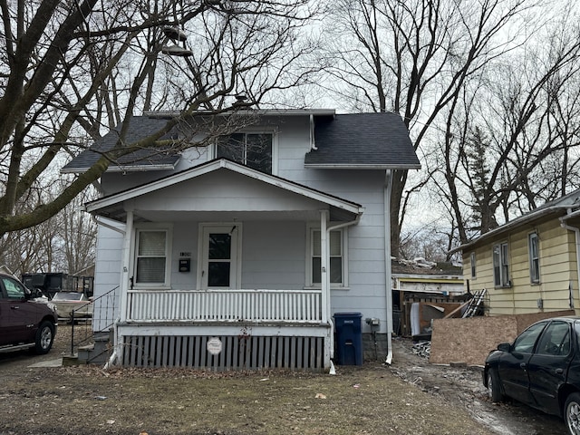 view of front facade with a porch and roof with shingles