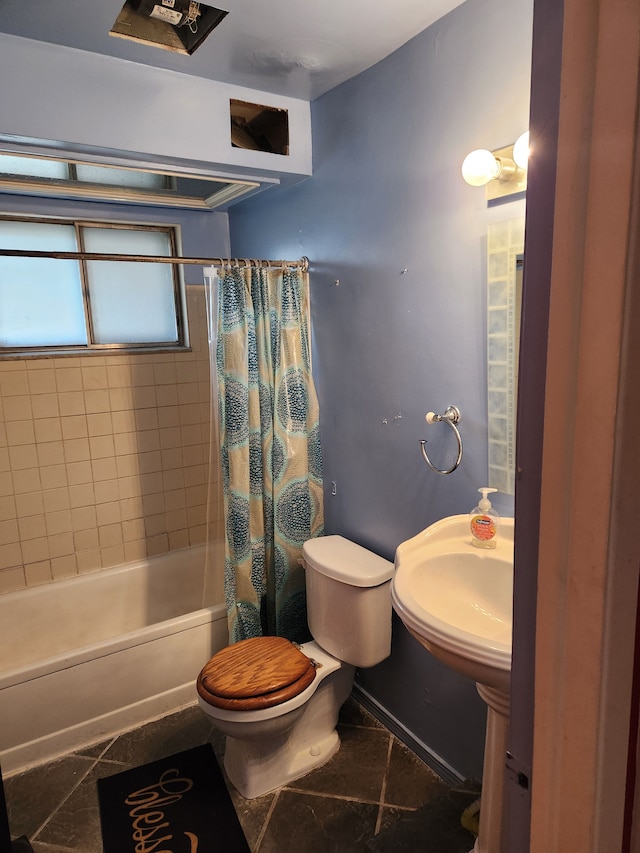 full bathroom featuring a sink, shower / tub combo with curtain, and toilet