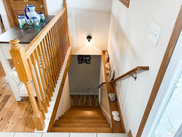 stairway featuring baseboards and wood finished floors