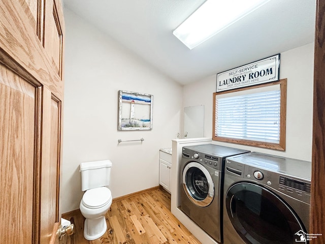 washroom with laundry area, light wood-style flooring, baseboards, and independent washer and dryer