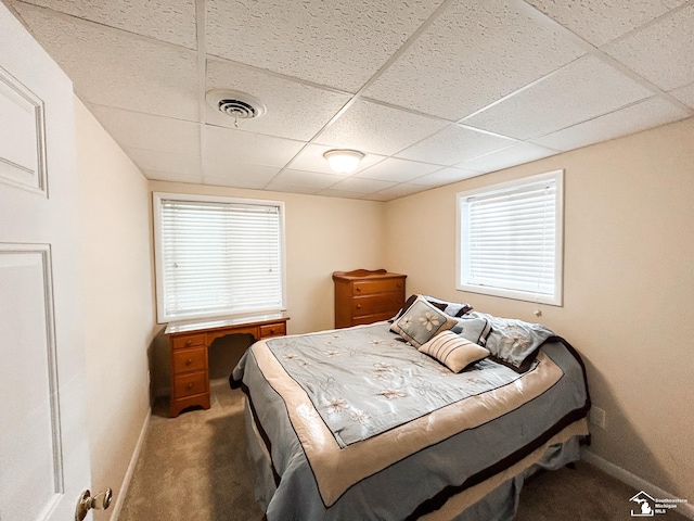 bedroom with carpet, visible vents, a drop ceiling, and baseboards