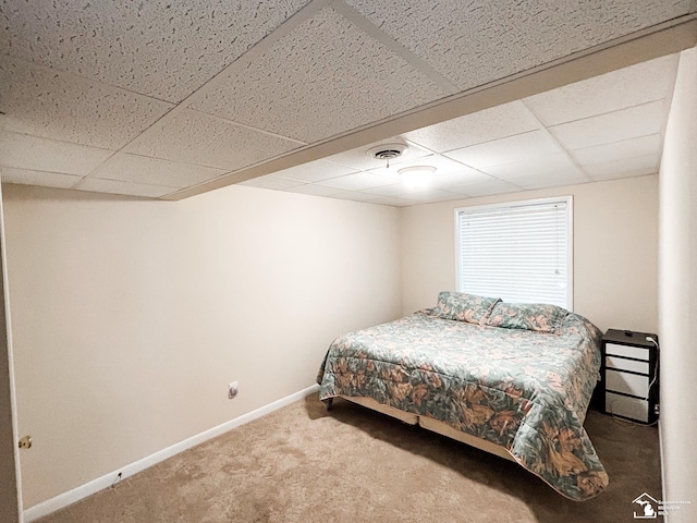 carpeted bedroom with a drop ceiling, visible vents, and baseboards