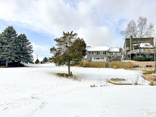 snowy yard featuring stairs