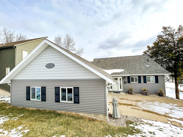 back of property featuring a patio area and roof with shingles