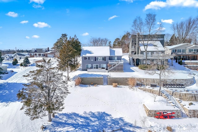 snow covered house with a residential view and stairway