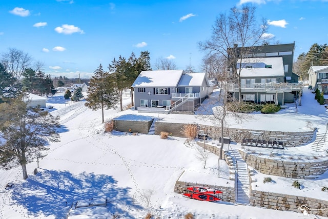 snow covered property with stairs and a residential view