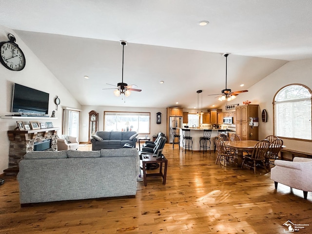 living area featuring light wood-type flooring, recessed lighting, a ceiling fan, and a stone fireplace