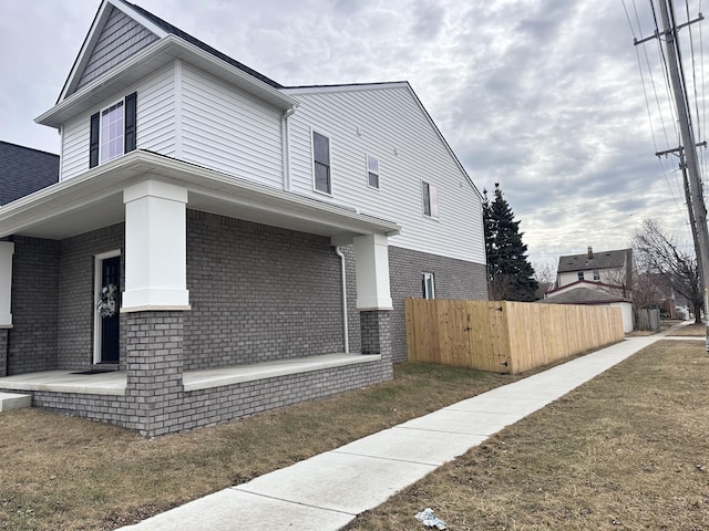 view of home's exterior with fence and brick siding